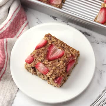 A square of strawberry baked oatmeal on a plate.