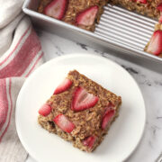 A square of strawberry baked oatmeal on a plate.