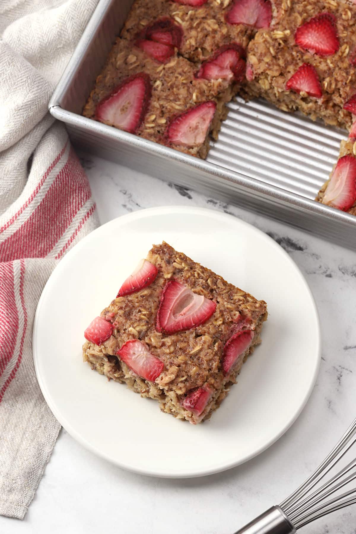 A square of strawberry baked oatmeal on a plate.