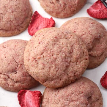 Strawberry sugar cookie stacked on a countertop.
