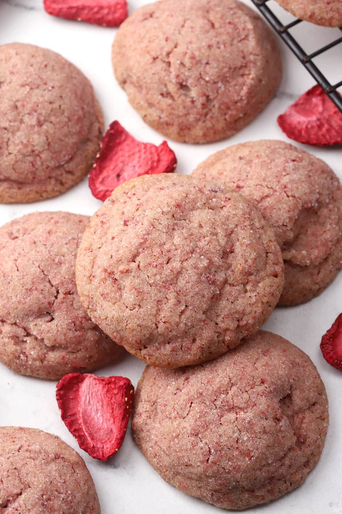 Strawberry sugar cookie stacked on a countertop.