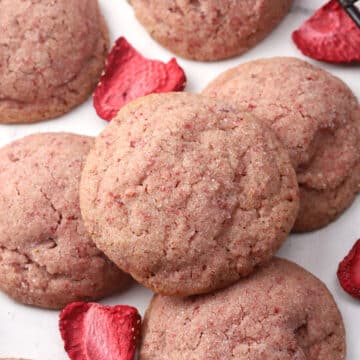 Strawberry sugar cookie stacked on a countertop.