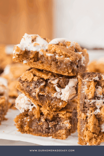 A stack of dessert bars on parchment paper and a cooling rack.