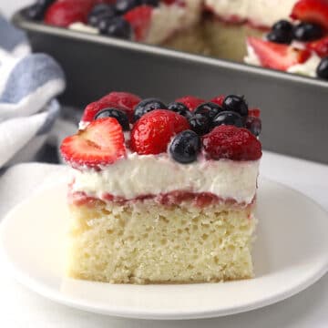 A slice of sheet cake with layered topping on a small plate with a fork.