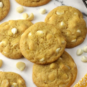 Lemon white chocolate macadamia nut cookies on a counter top.