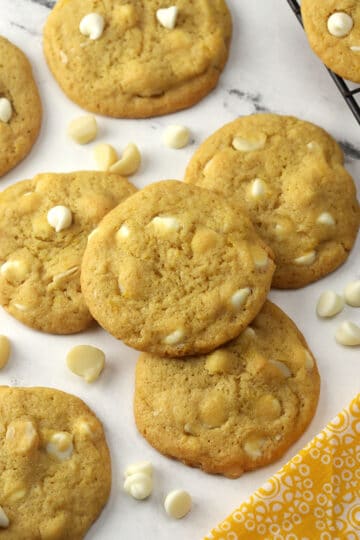 Lemon white chocolate macadamia nut cookies on a counter top.