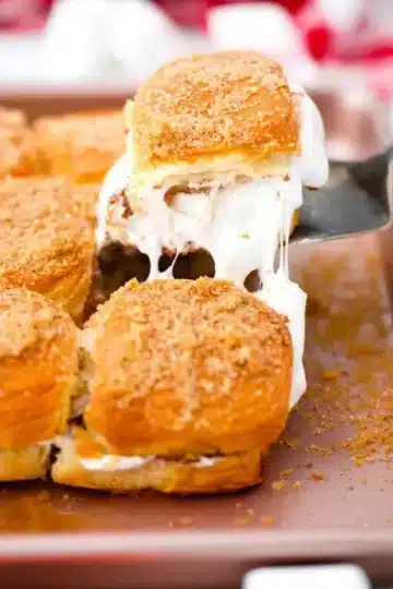 A single s'mores slider being pulled from a group with a spatula.