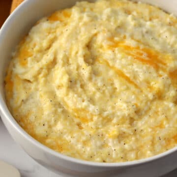 A white bowl filled with cheesy grits.