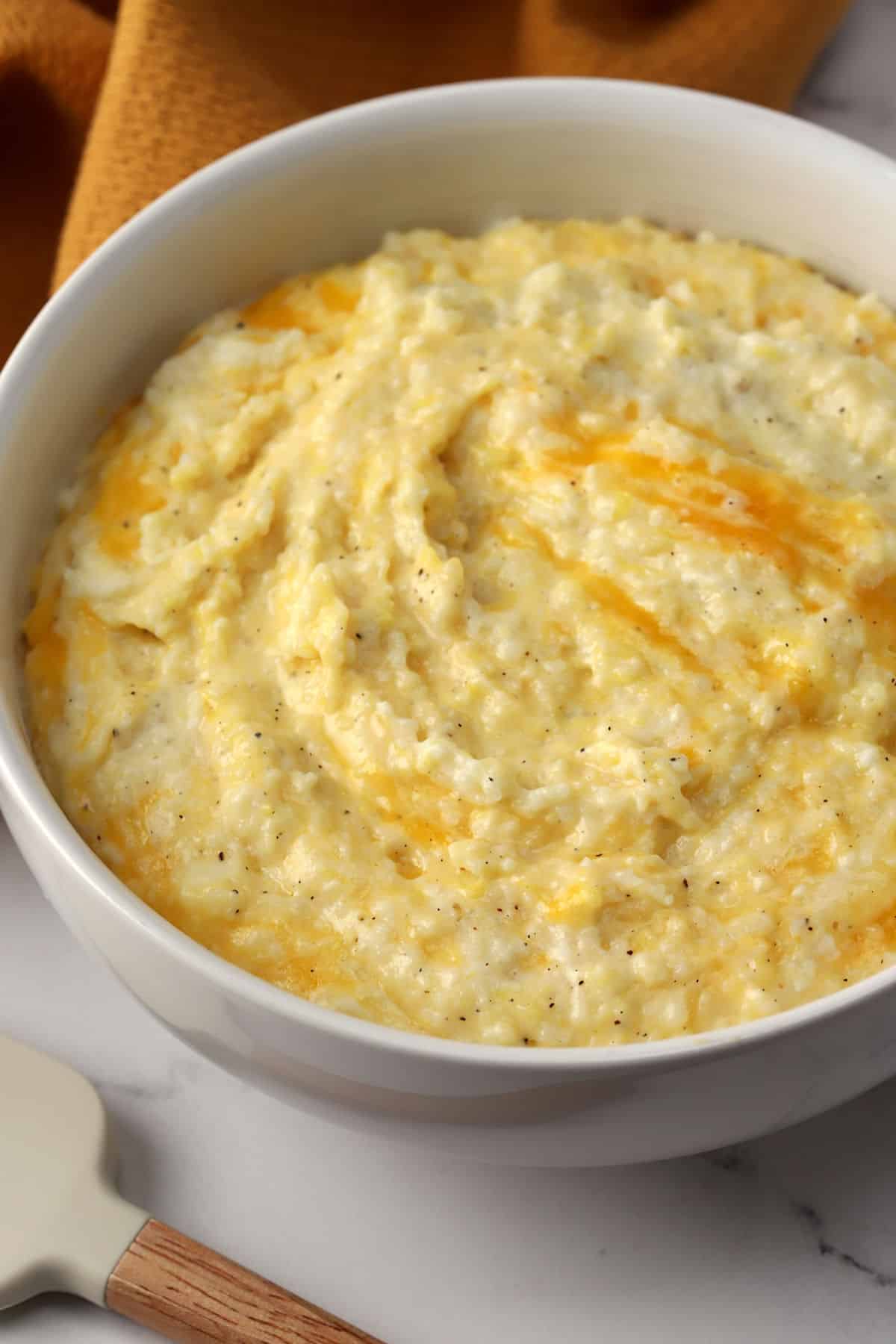 A white bowl filled with cheesy grits.