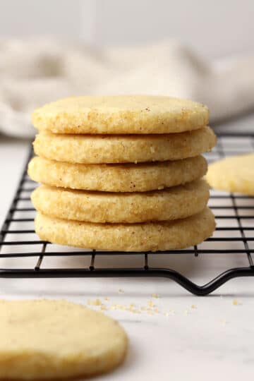 A stack of heidesand brown butter cookies on a cooling rack.