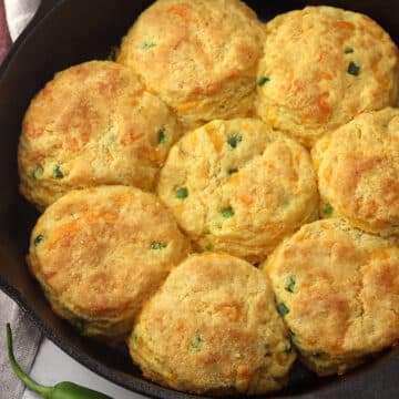 A cast iron pan filled with jalapeno cheddar cornmeal biscuits.