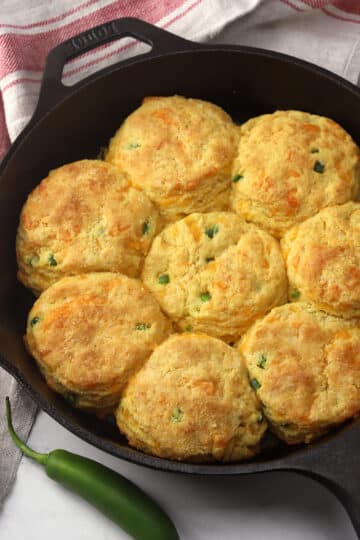 A cast iron pan filled with jalapeno cheddar cornmeal biscuits.
