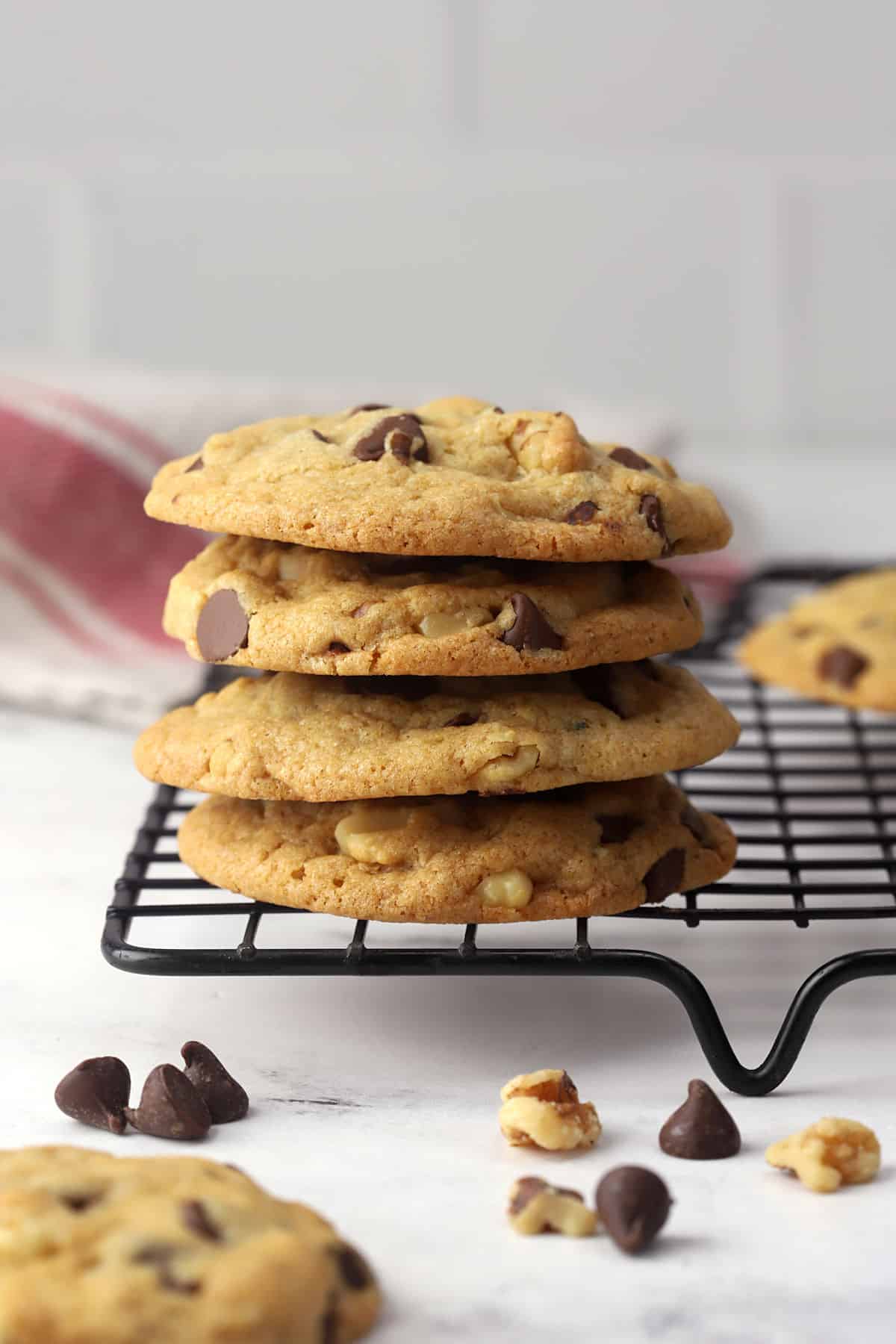 A stack of chocolate chip cookies on a cooling rack.