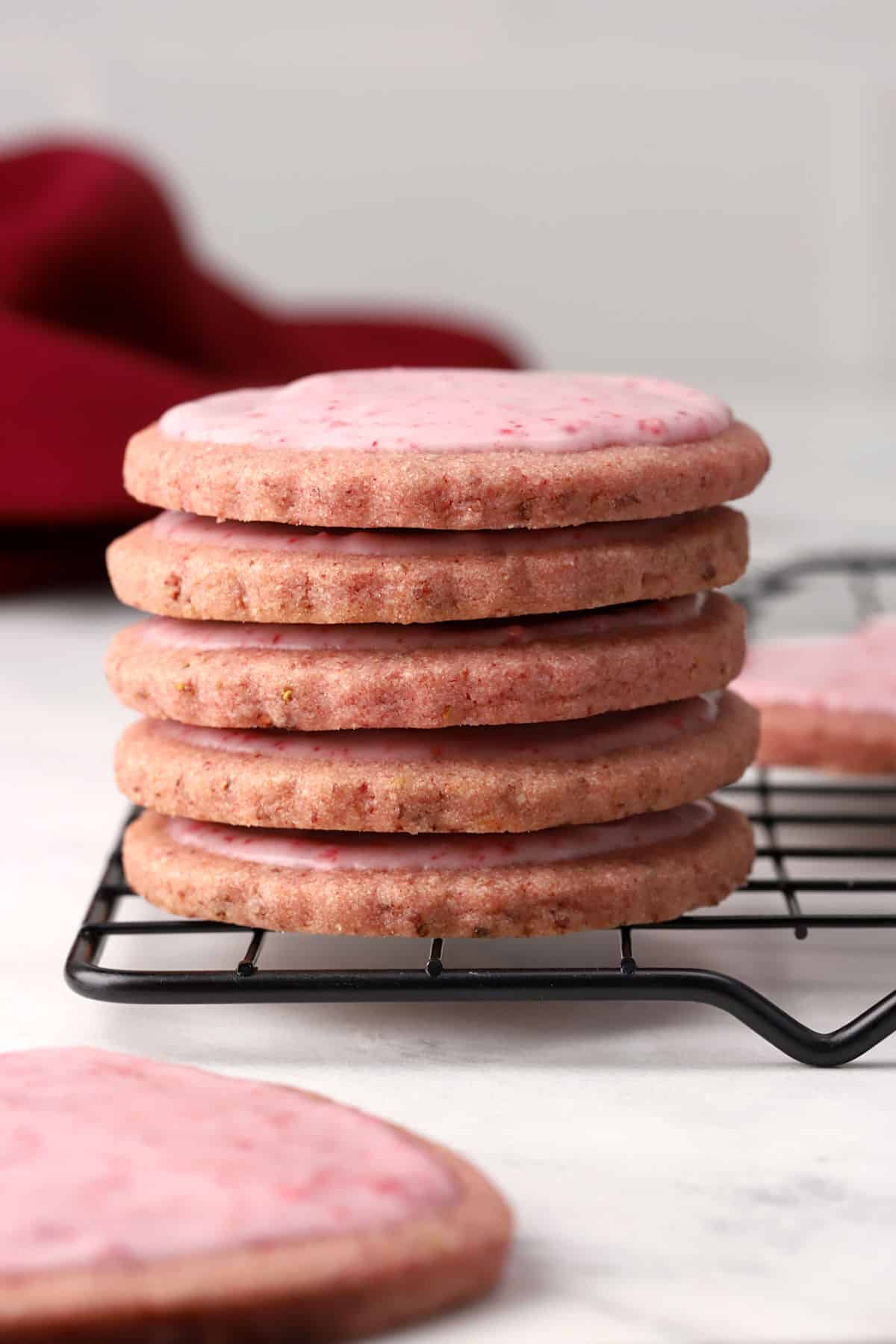 A stack of strawberry sugar cookies on a cooling rack.