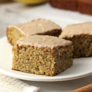 Zucchini banana bread bars sliced into squares on a small white plate.