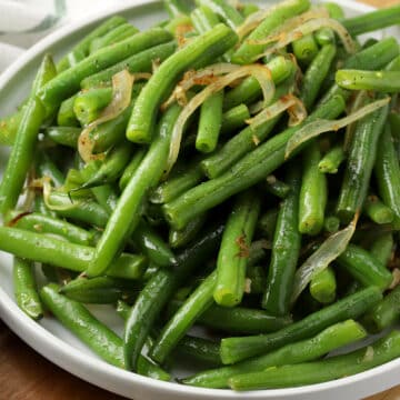 Green beans and onions in a skillet.