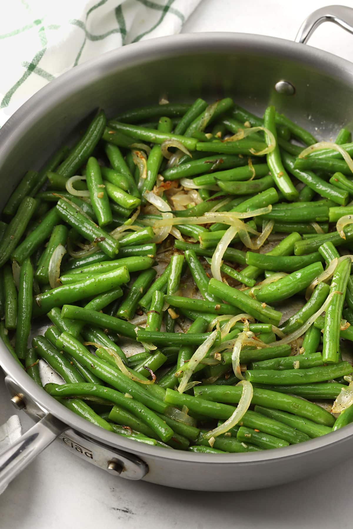 Green beans and onions in a skillet.