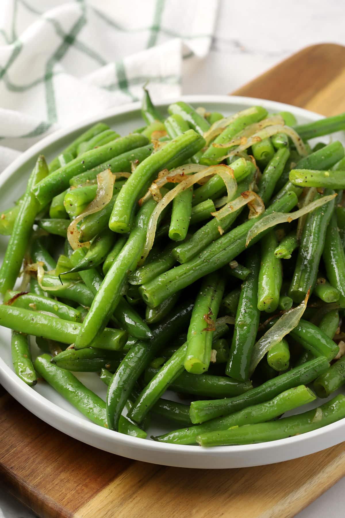 Green beans and onions on a round plate.
