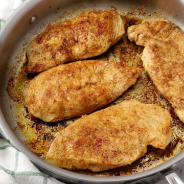 Seared chicken breasts in a pan.