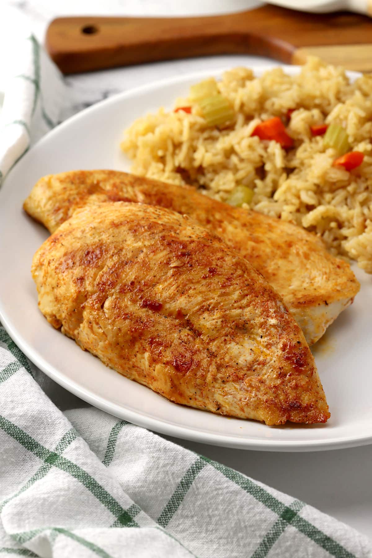 Chicken breasts with rice pilaf on a plate.