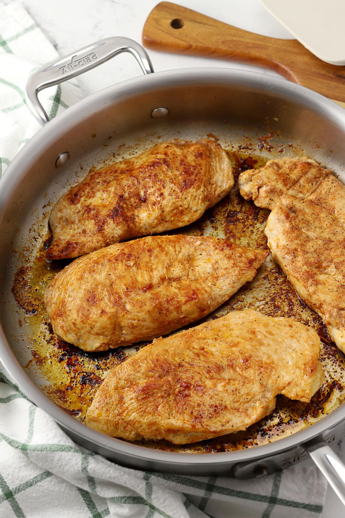 Seared chicken breasts in a pan.