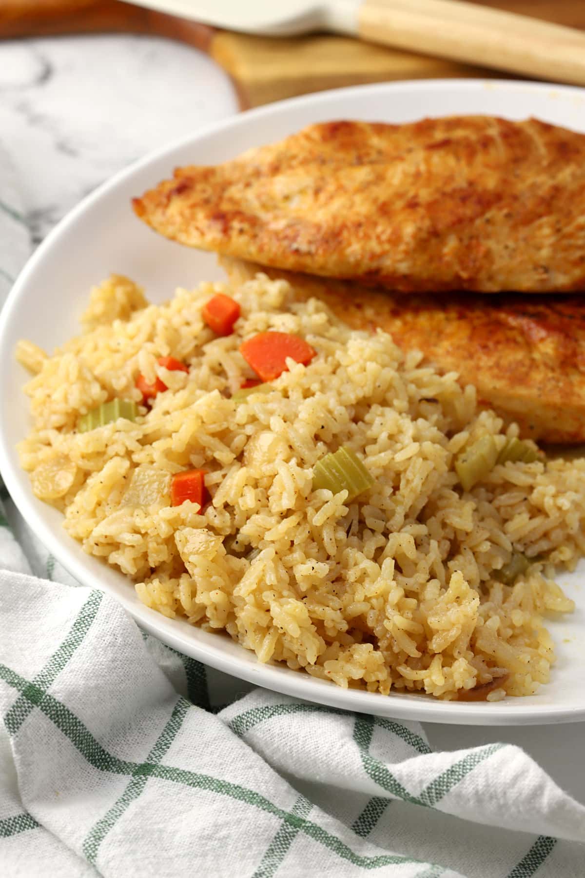 Rice pilaf on a plate with seared chicken breasts.