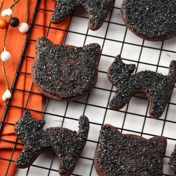 Black cat cookies on a cooling rack.