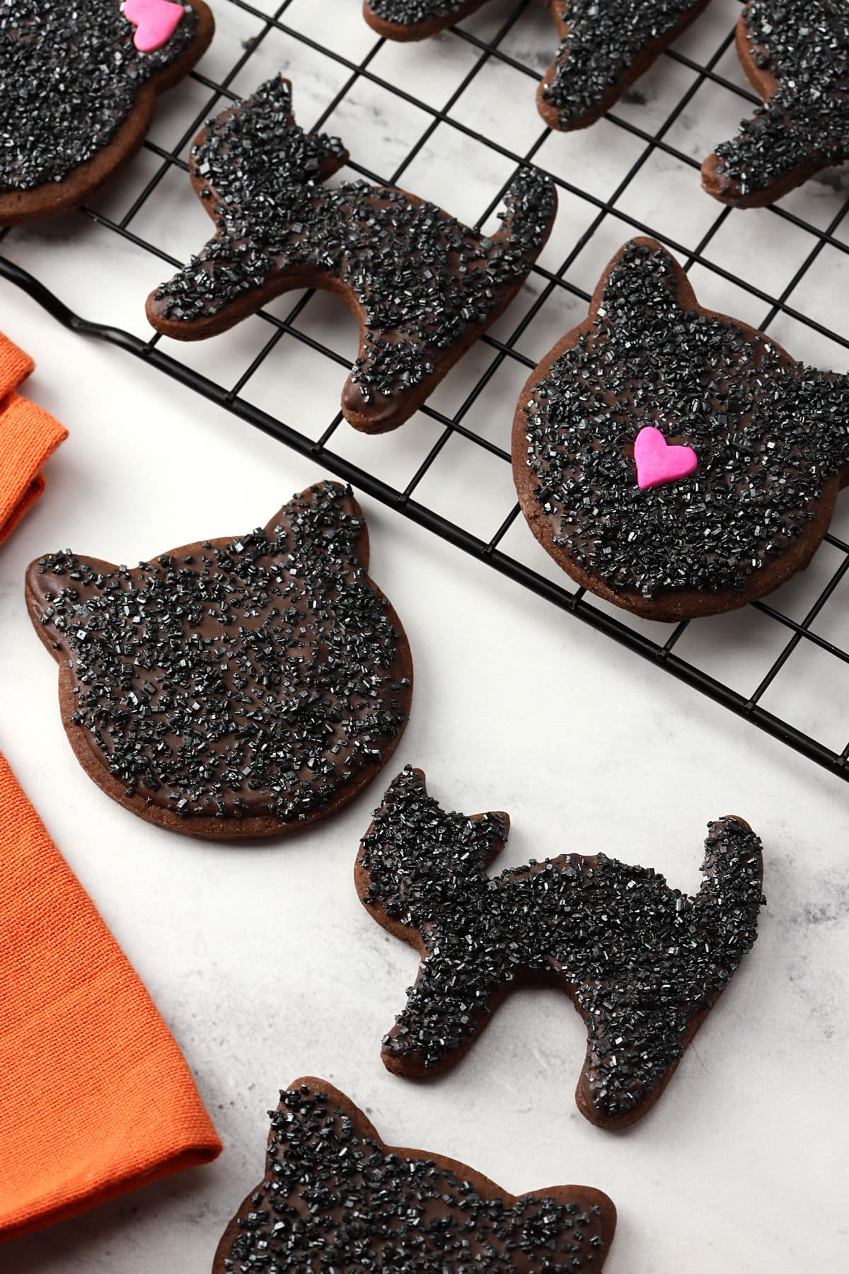 Black cat cookies with decorative sprinkles.