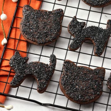 Black cat cookies on a cooling rack.