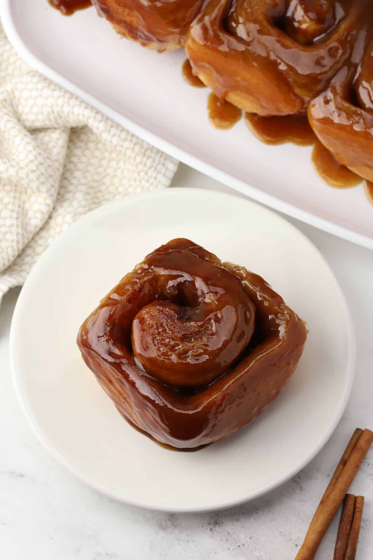A caramel roll on a small plate.
