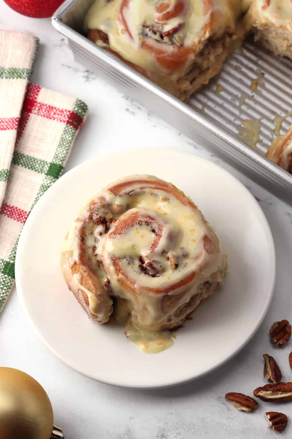 A frosted cinnamon roll on a small plate.