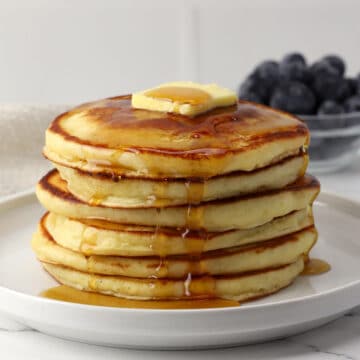 A stack of pancakes with butter and syrup on top.