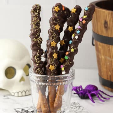 Glass filled with pretzel wands decorated with sprinkles.