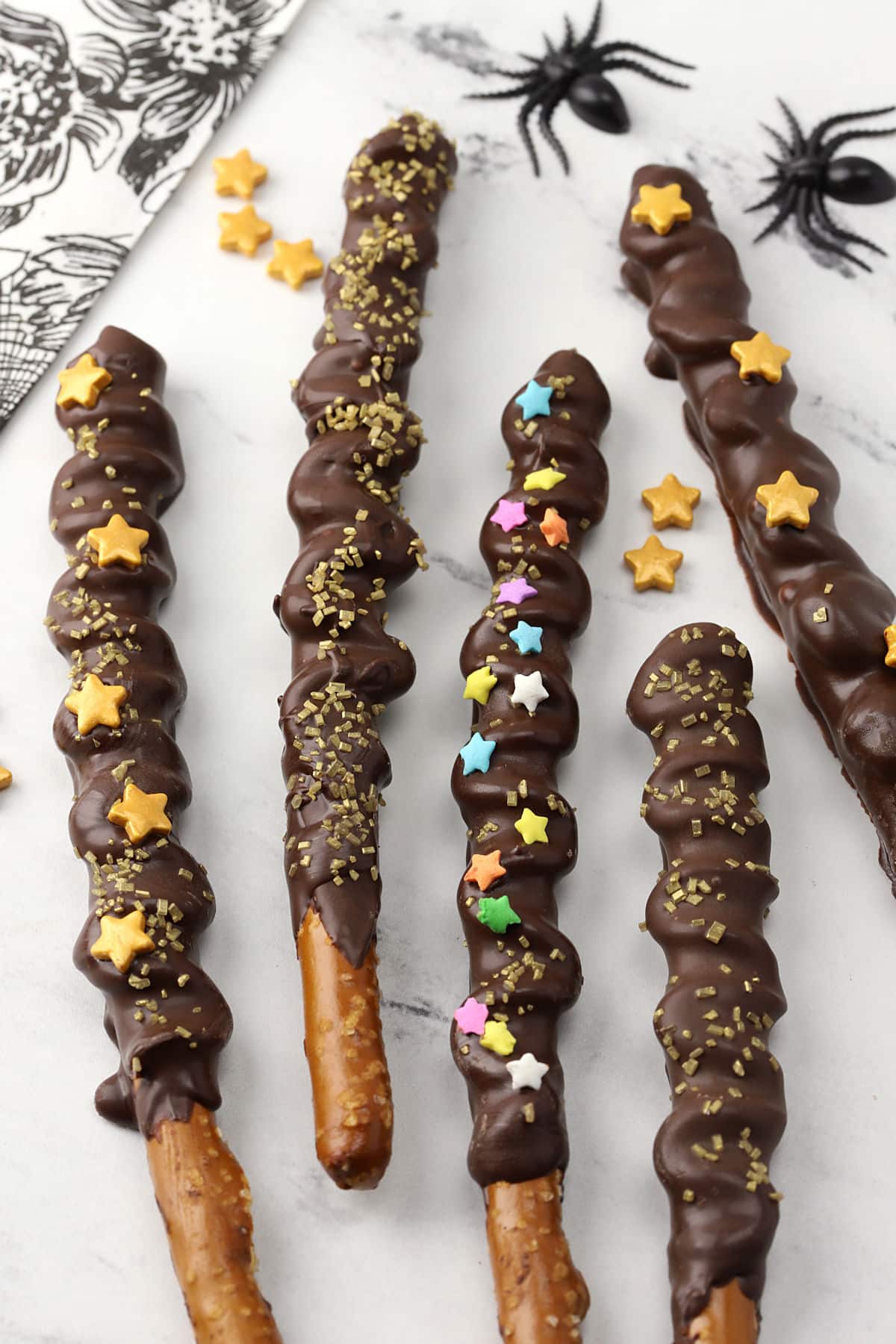 Pretzel wands laying on a countertop covered in star sprinkles.