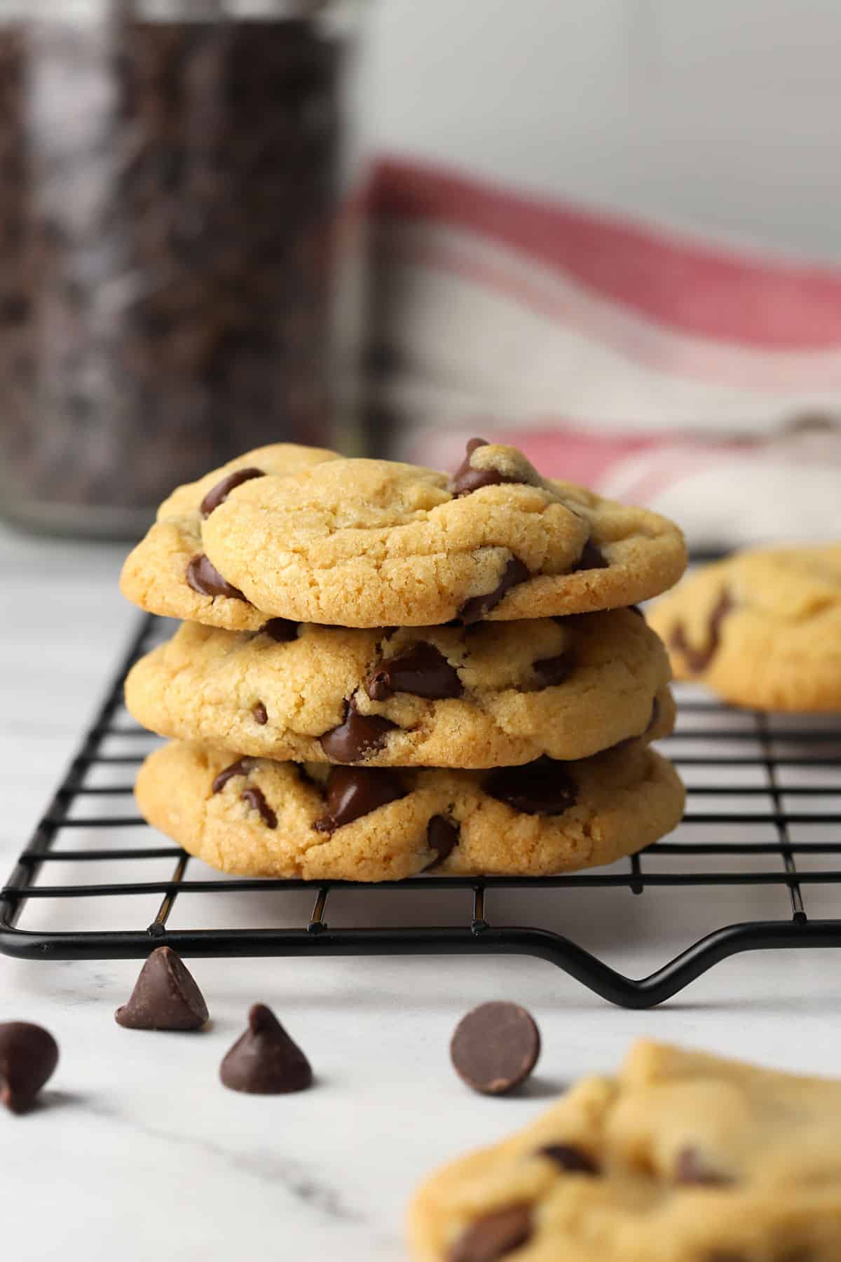 Stack of chocolate chip cookies on a cooling rack.