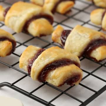 Close up of raspberry rugelach sitting on a metal cooling rack.