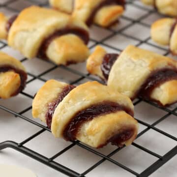 Close up of raspberry rugelach sitting on a metal cooling rack.