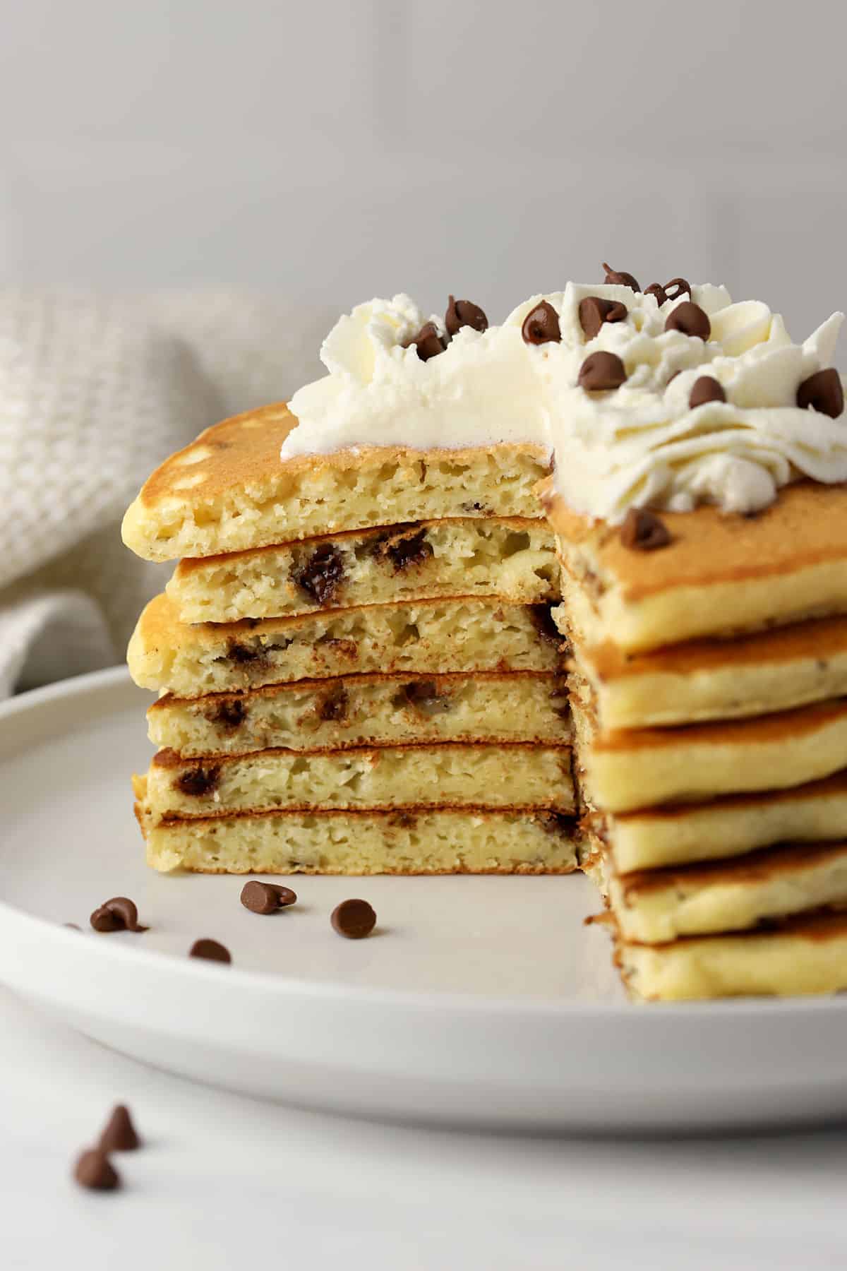 A stack of chocolate chip pancakes sliced to show layers.