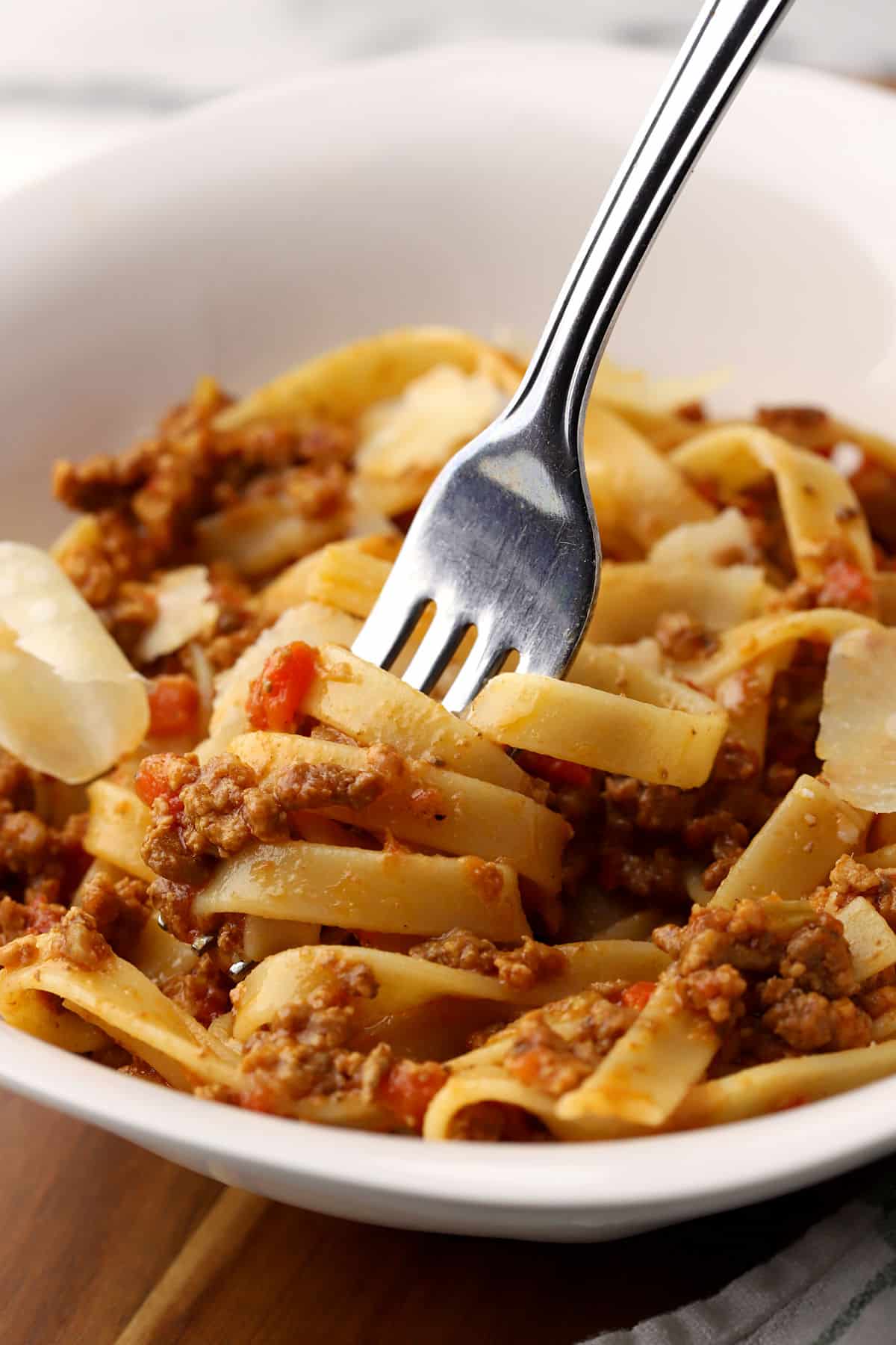 A fork twirling fettuccine with bolognese.