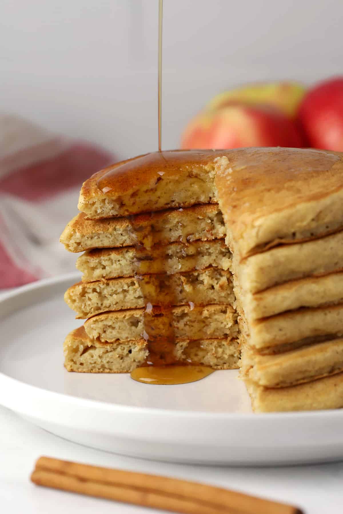 A stack of sliced pancakes with maple syrup poured on top.