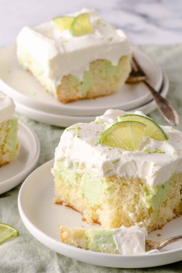 Slices of key lime poke cake on plates with forks.