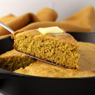 A slice of cornbread with butter melting on top.