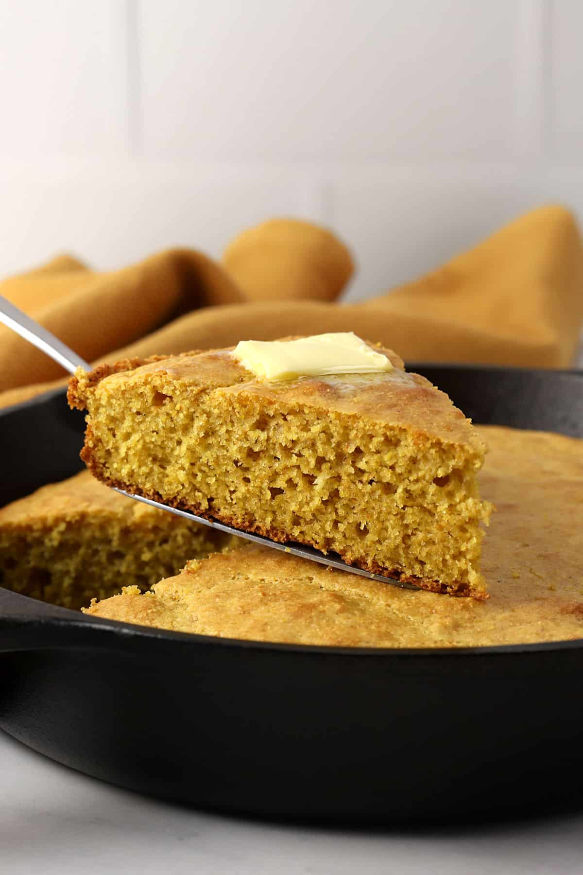 A slice of cornbread with butter melting on top.