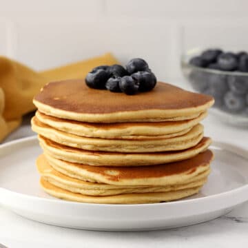A stack of pancakes with blueberries.