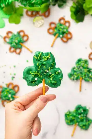 Chocolate covered pretzels decorated with sprinkles and shaped like shamrocks.