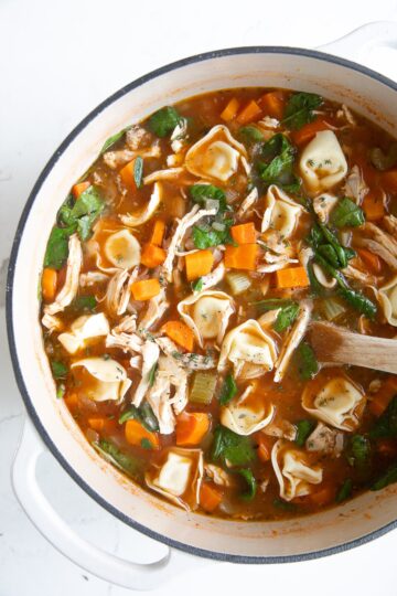 A crock pot of chicken, vegetable, and tortellini soup.