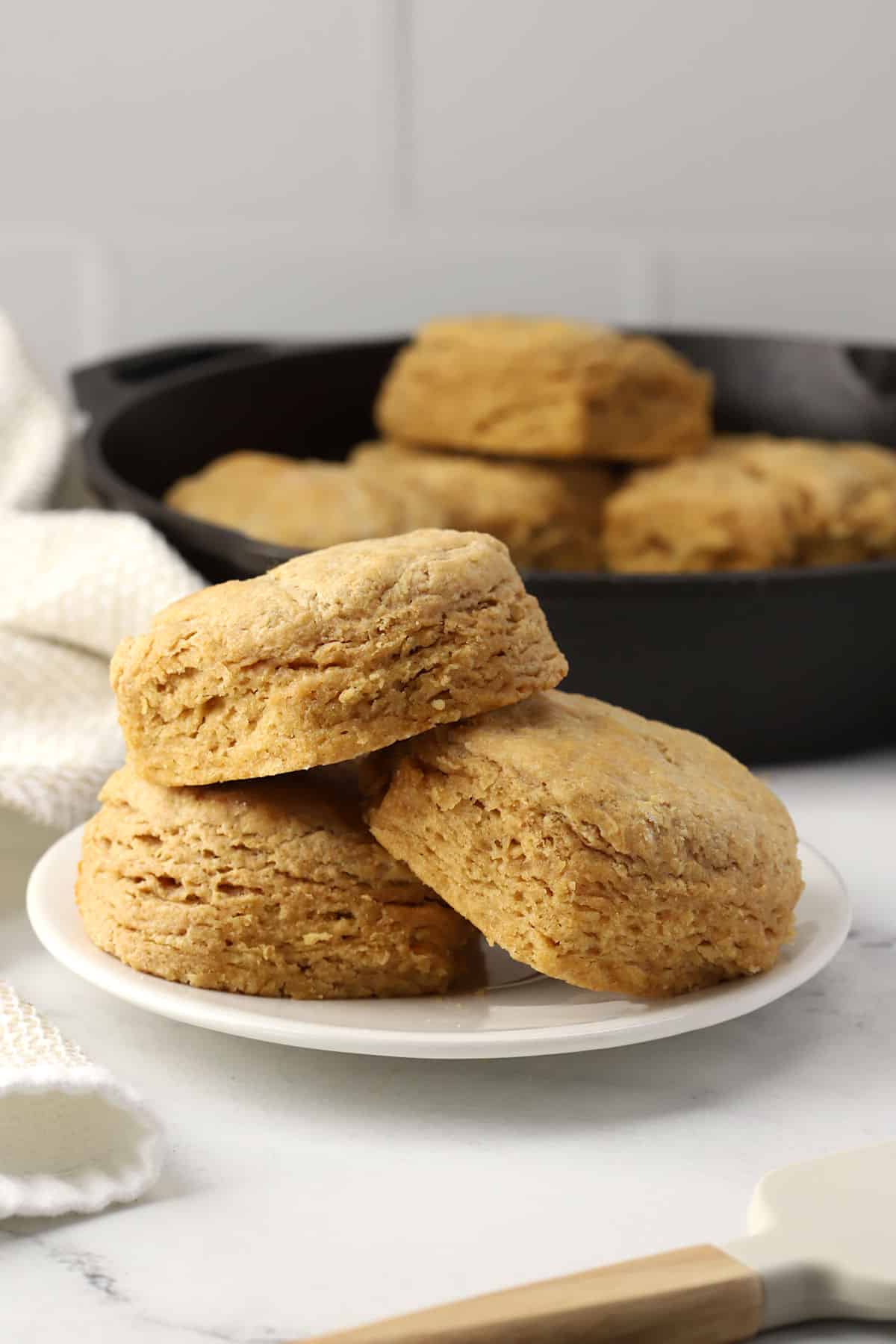 Three biscuits stacked on a plate.