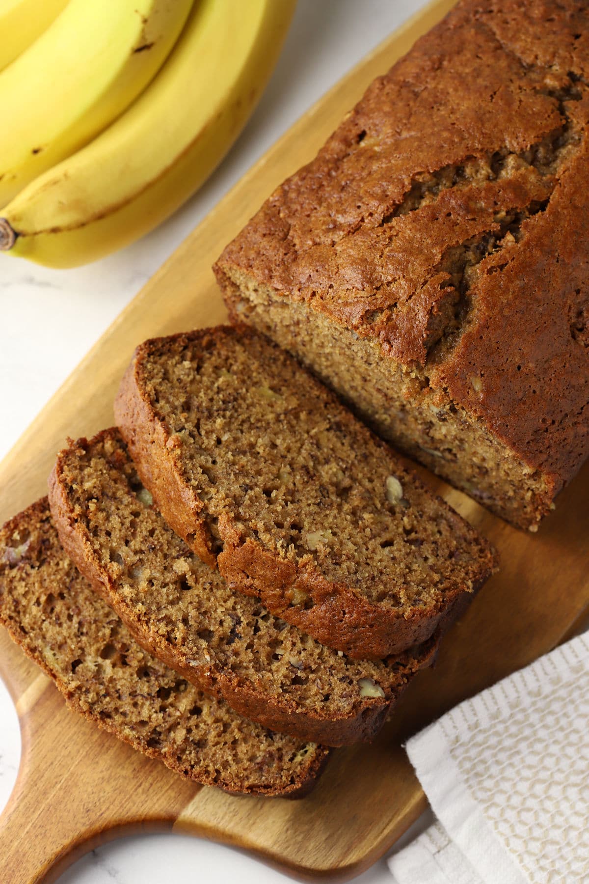 A loaf of sliced banana bread on a cutting board.