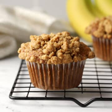 A spelt banana muffin on a cooling rack.