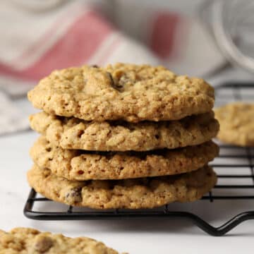 A stack of oatmeal raisin cookies on a cooling rack.